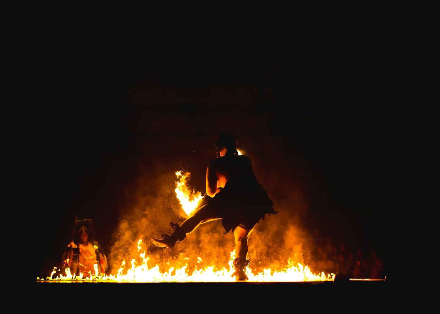 A fire performer at night, mid-act